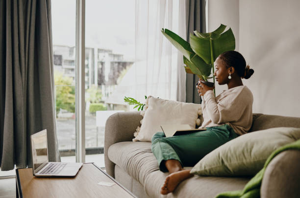 photo d’une jeune femme prenant un café et se relaxant à la maison - confort maison photos et images de collection